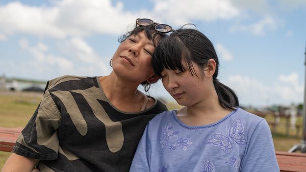Take Me Home film image; two women with their heads pressed together