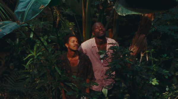 Taxi Moto film image; two people in a forest looking up