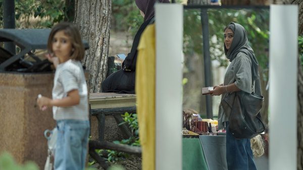 These Voices Are Real film image; child throwing something in a garbage can outside
