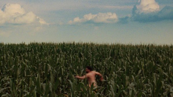 Udders! film image; naked man running through a cornfield