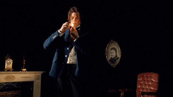 A. Rimbaud film image; man lighting a pipe