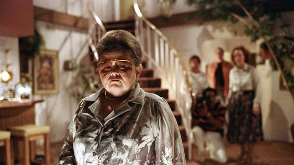 Poltergeist film image; woman standing in a suburban house