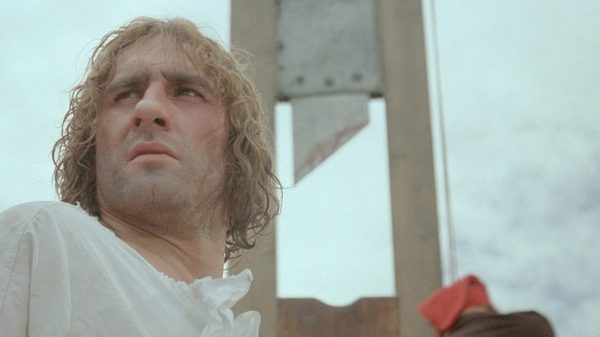 Danton film image; man standing in front of a guillotine