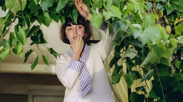 The Maids of Wilko film image; woman lingering under a tree's canopy